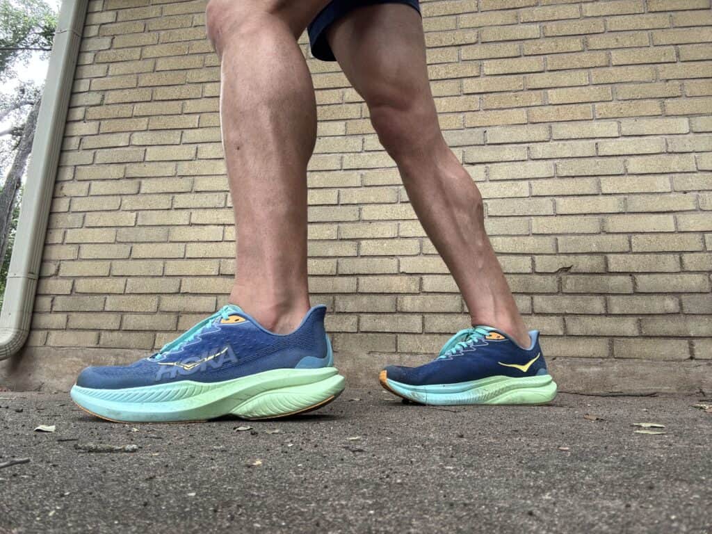 Writer Brady Holmer wearing the Hoka Mach 6 for a test run, pictured against a brick wall.