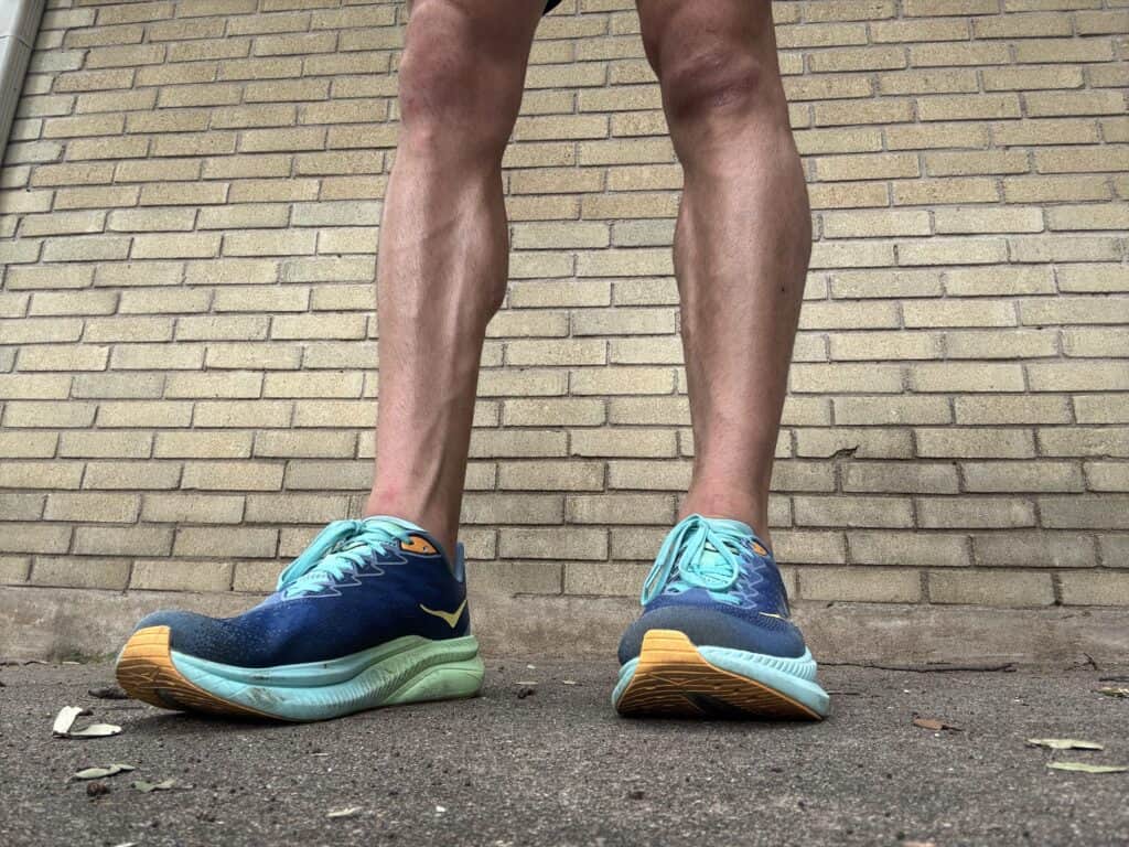 Writer Brady Holmer wearing the Hoka Mach 6 against a brick wall.