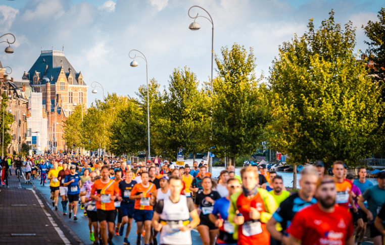 Runners racing down the street in Amsterdam in one of the best European half marathons, the Amsterdam Half Marathon.