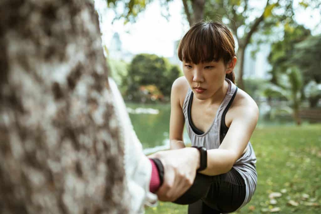 A female runner stretching before she does a workout, possibly to help reduce injury risk.