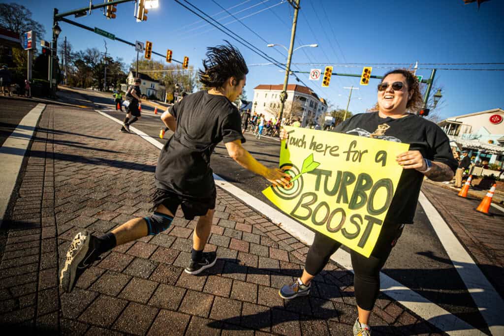 A spectator at the Richmond Marathon holding a fun sign to encourage runners.