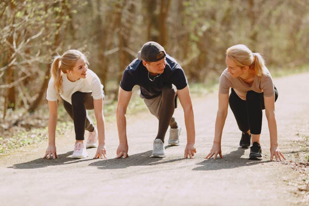 Three female runners getting ready to do sprint training.