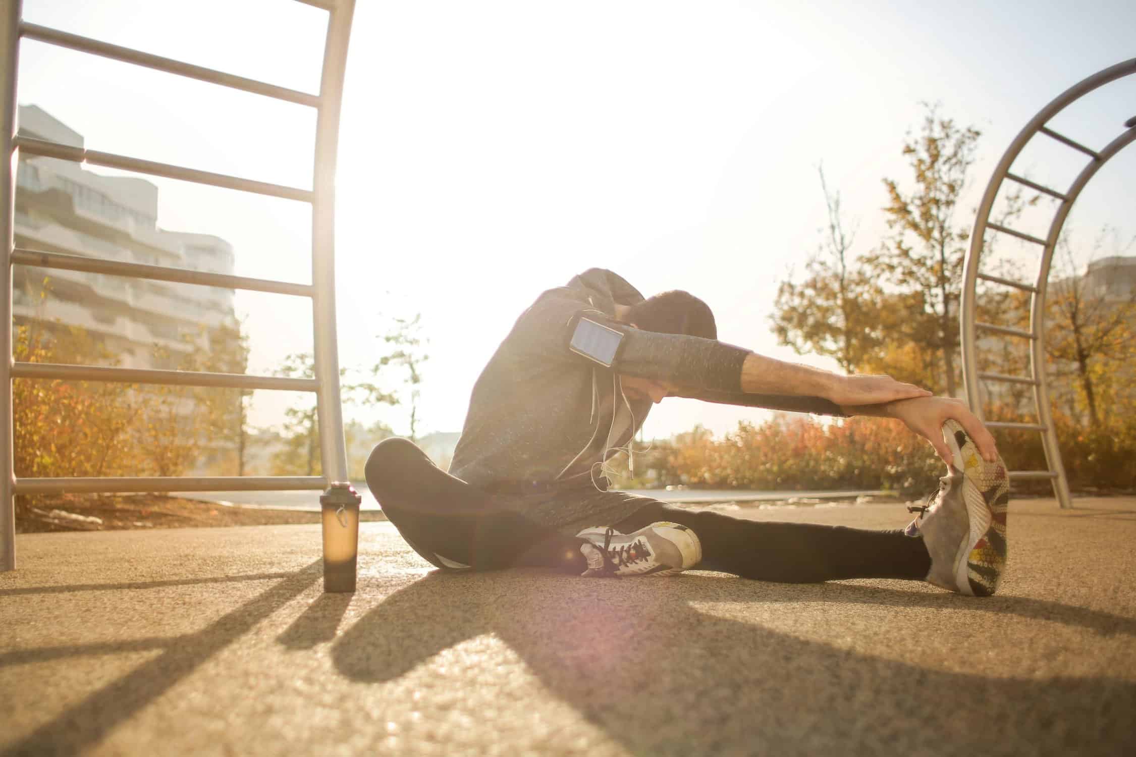 A runner wearing headphones, listening to good hype music while warming up